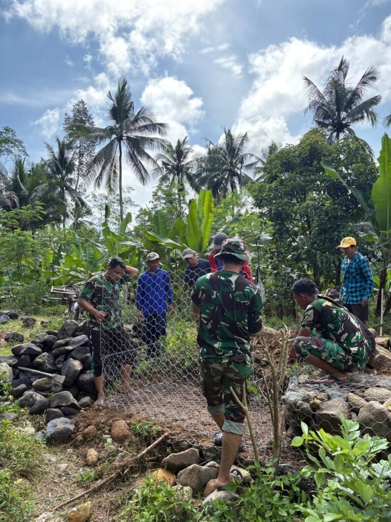 Anggota Satuan Tugas TNI Manunggal Membangun Desa (TMMD) ke-126 Kodim 0818/Malang-Batu yang berasal dari AURI terus melanjutkan pekerjaan pemasangan bronjong batu di Dusun Sukomaju B