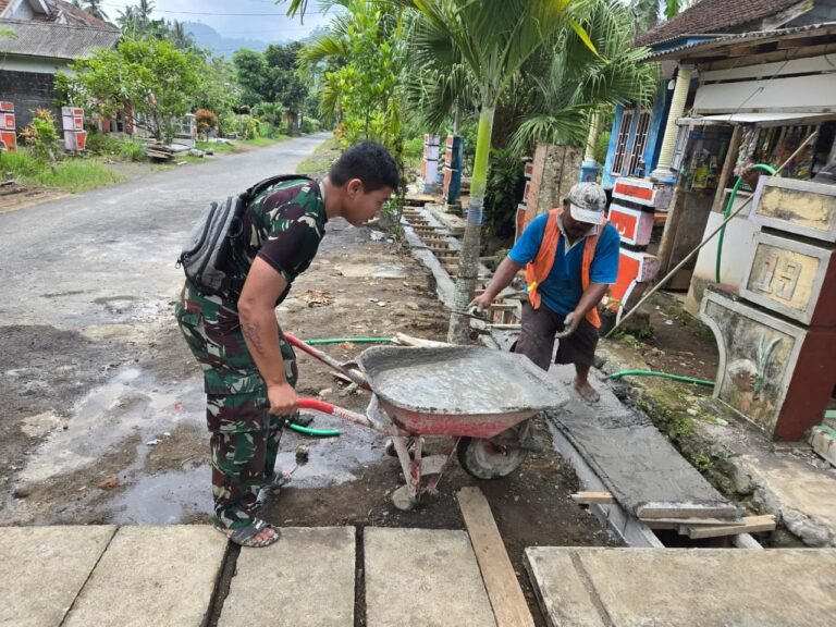 personel Satuan Angkatan Udara Republik Indonesia (AURI) bersama warga melanjutkan pekerjaan pengecoran drainase di Dusun Krajan 1B, Desa Lebakharjo, Kecamatan Ampelgading, Kabupaten Malang